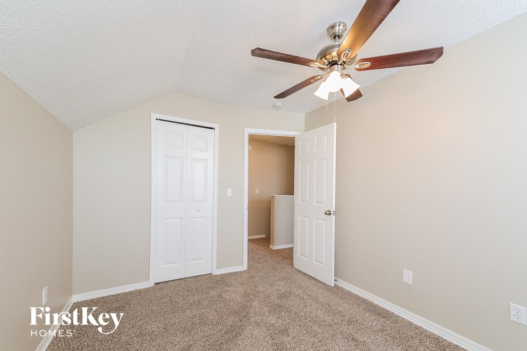 a bedroom with a ceiling fan and a closet