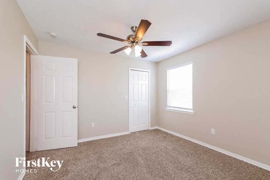 the master bedroom has a ceiling fan and a closet