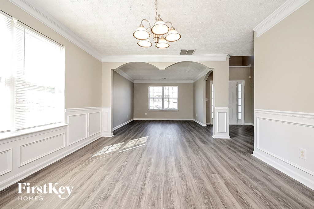 an empty living room with white walls and wood floors