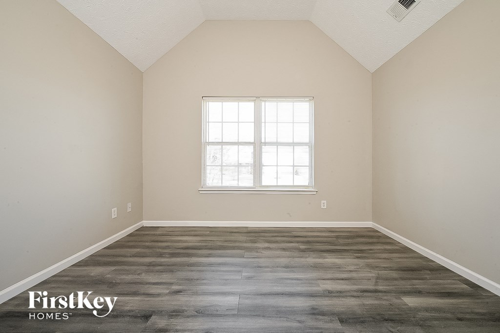 an empty room with wood floors and a window