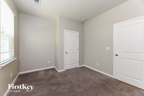 a bedroom with a carpeted floor and two white doors