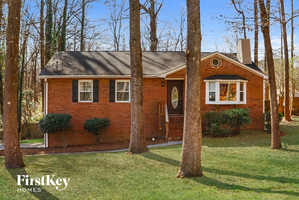 a small red brick house with trees in front of it