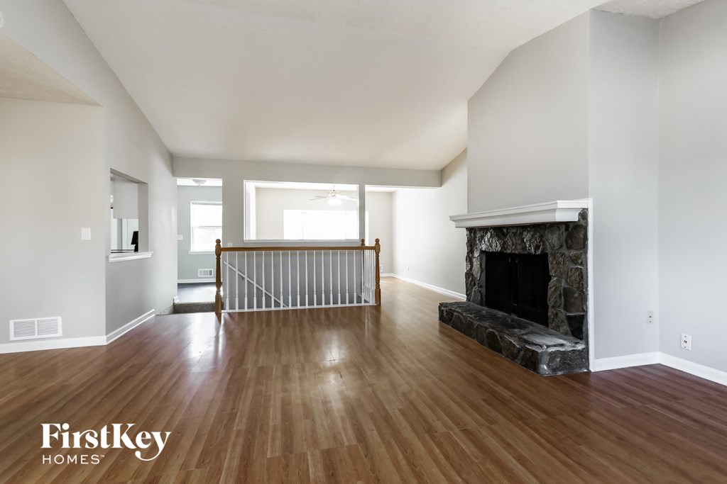 a living room with a fireplace and a wooden floor