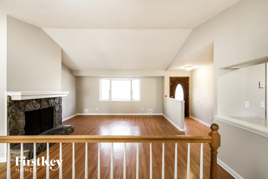 a living room with a fireplace and a wooden staircase