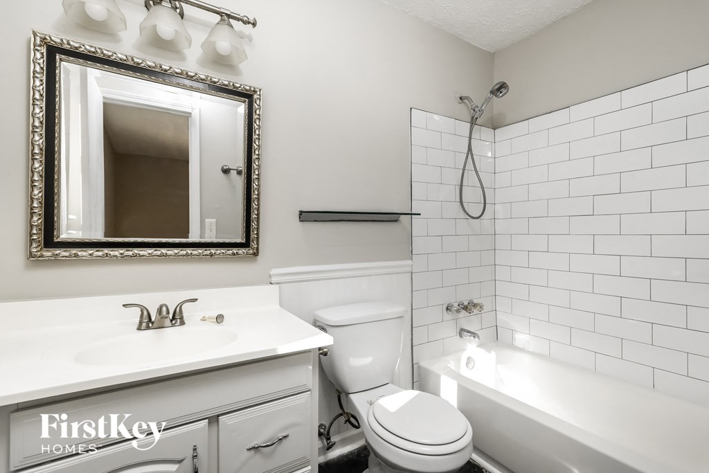 a white bathroom with a white toilet and tub and a sink