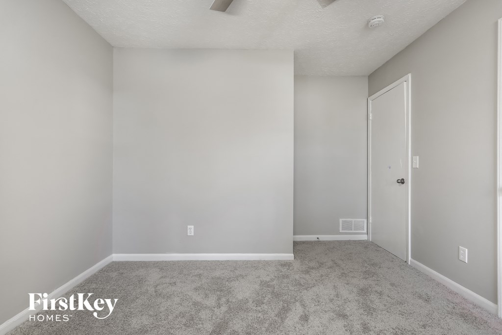 a bedroom with a carpeted floor and a door to a closet