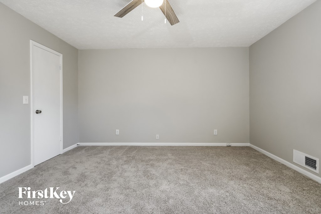 a bedroom with a carpeted floor and a ceiling fan