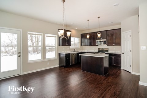 a kitchen with dark wood cabinets and an island in the middle