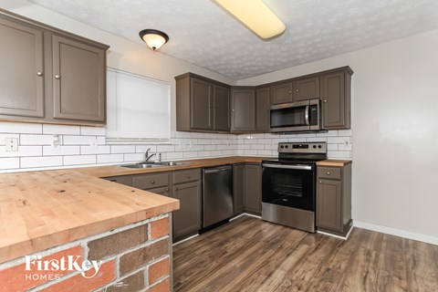 A kitchen with wooden cabinets and a brick counter.
