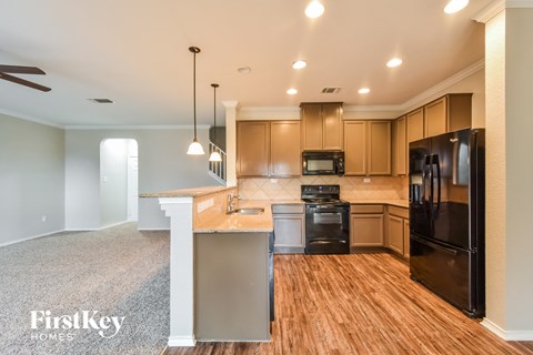 A kitchen with wooden cabinets and black appliances.