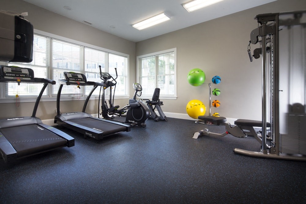 A gym with treadmills, exercise balls, and weights.
