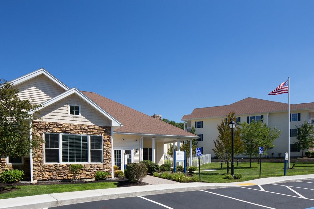 A small building with a flag on top is in front of a larger building.