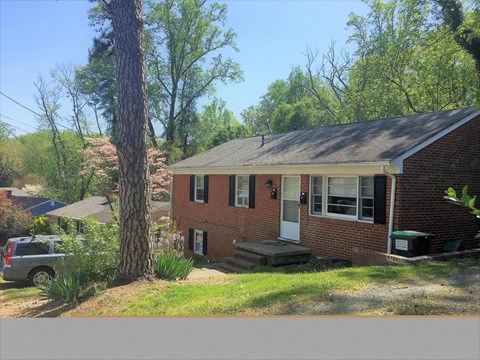 A house with a white door and a green box on the front porch.