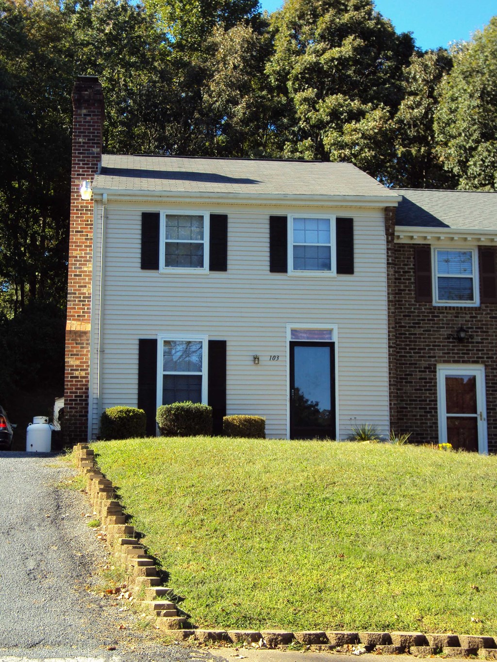 a white house with black shutters and a lawn