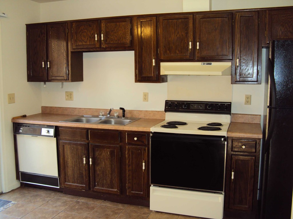a kitchen with black and white appliances and wooden cabinets
