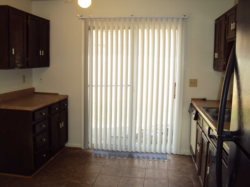 a kitchen with a window with white blinds