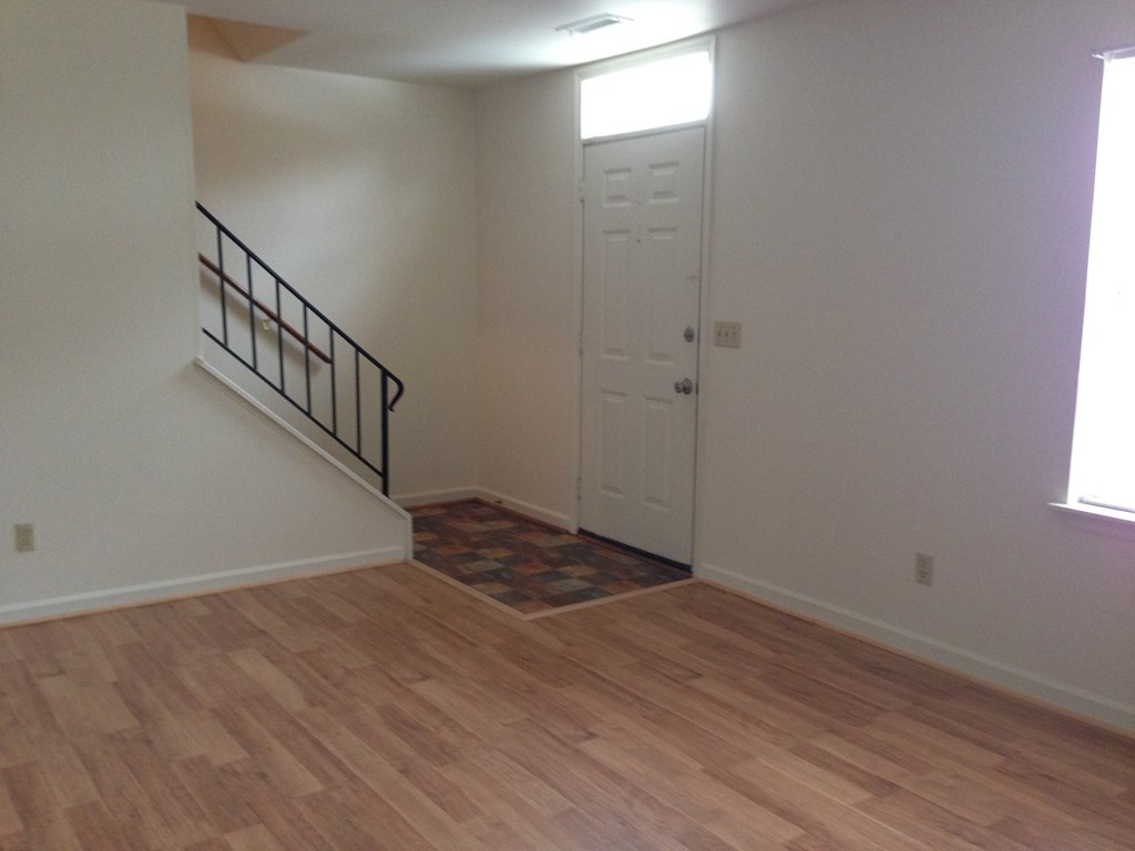 an empty room with a staircase and a white door