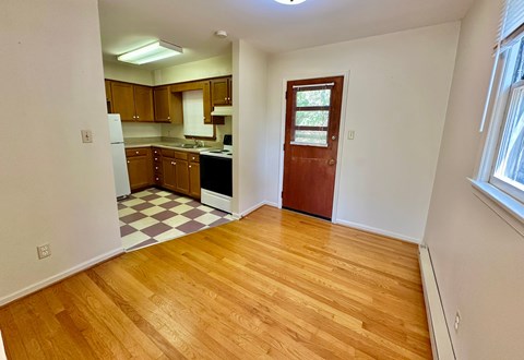 A kitchen with wooden floors and a checkered floor in the middle.