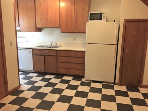 A kitchen with a black and white checkered floor.