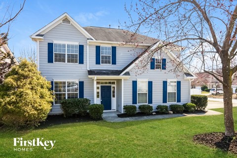 a blue and with blue shutters and a lawn