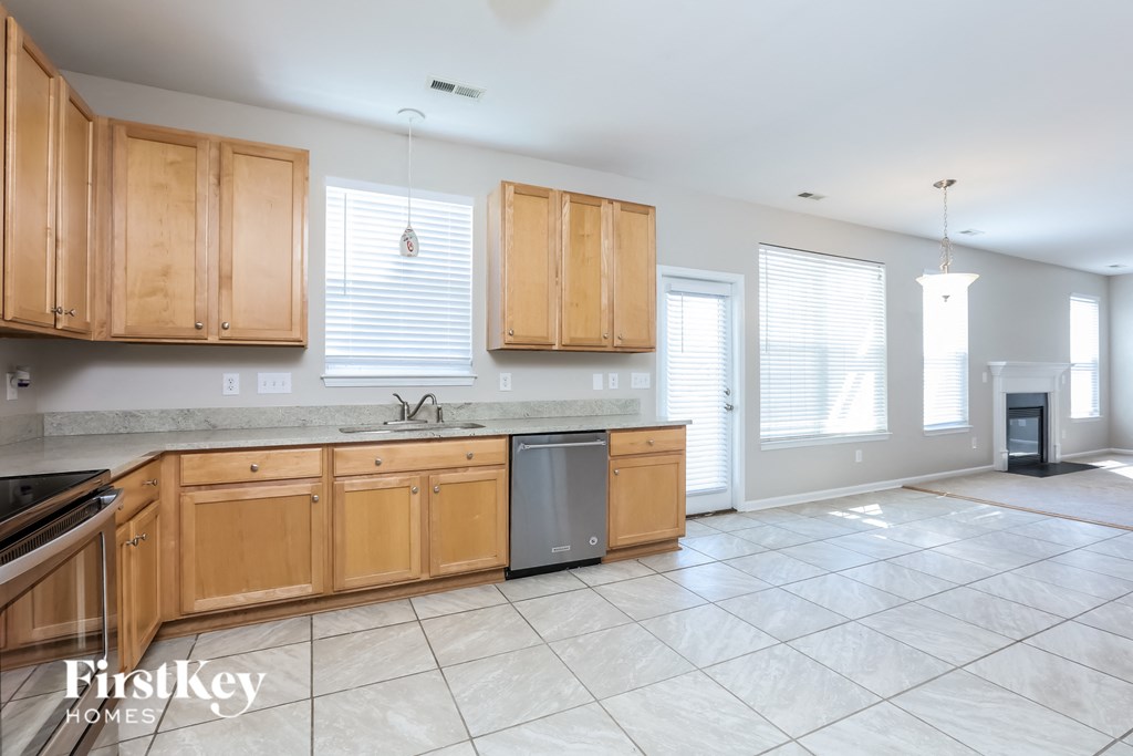 a large kitchen with wooden cabinets and tile flooring