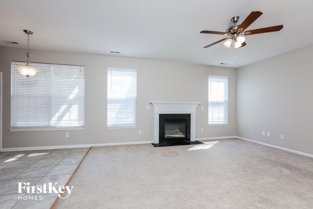 a living room with a fireplace and a ceiling fan