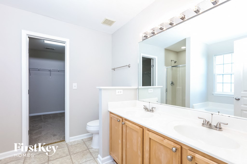 a bathroom with a large mirror and a sink and a toilet