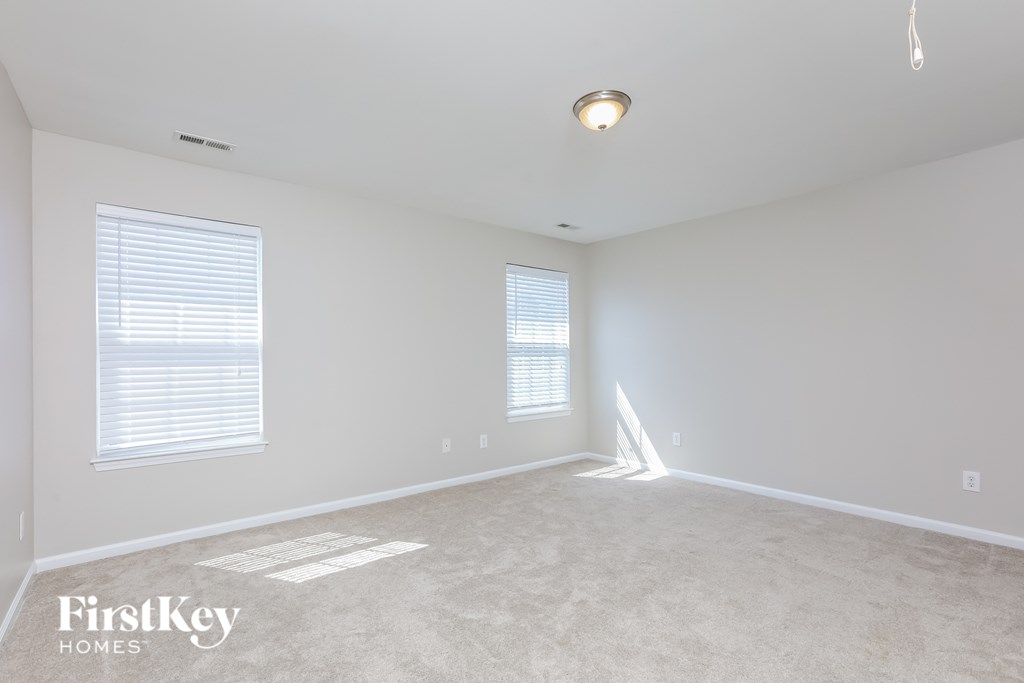 a bedroom with a carpeted floor and two windows