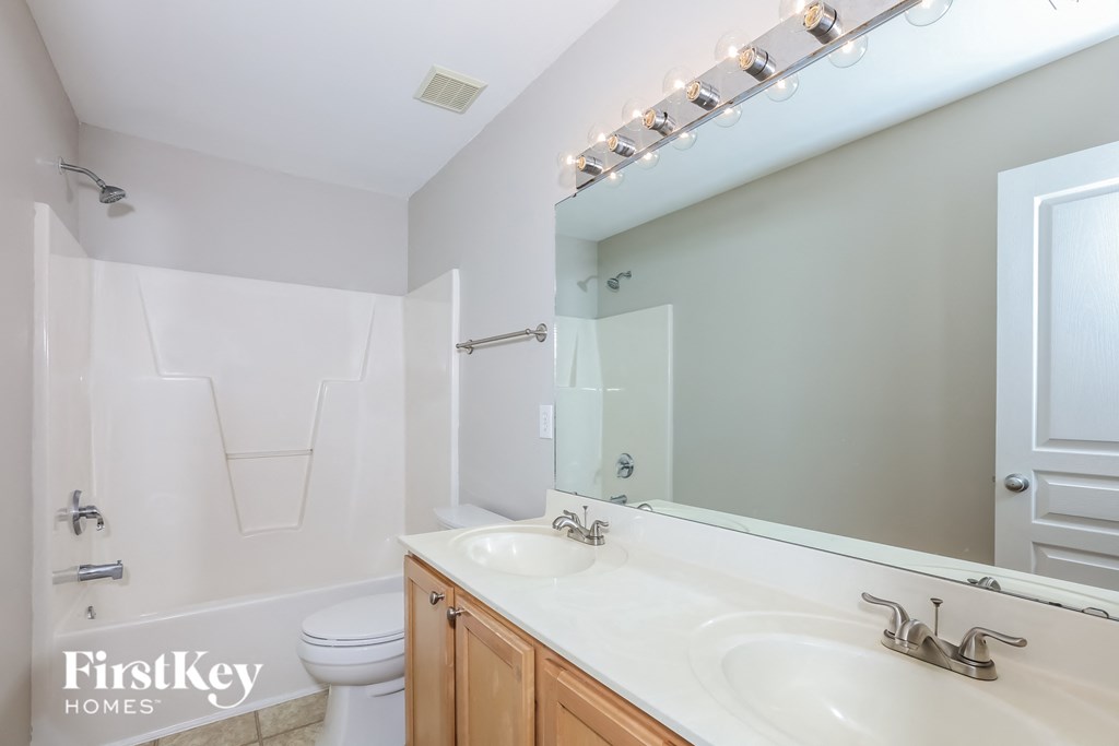 a bathroom with two sinks and a mirror and a toilet