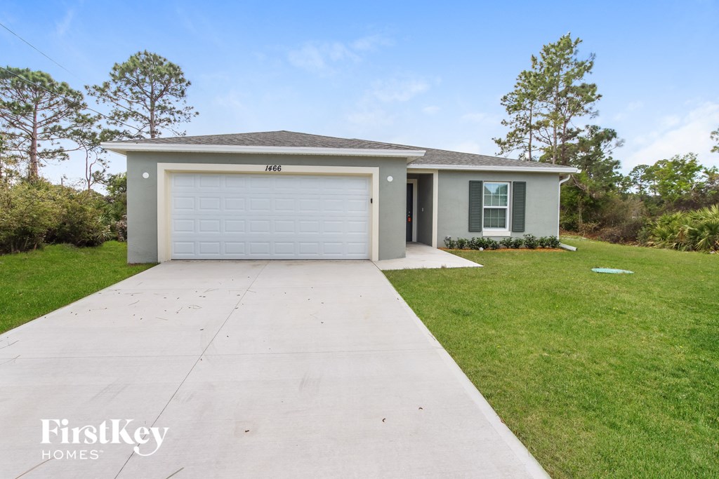 A house with a garage and a driveway is for sale.
