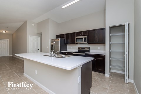 A kitchen with a white counter top and black cabinets.
