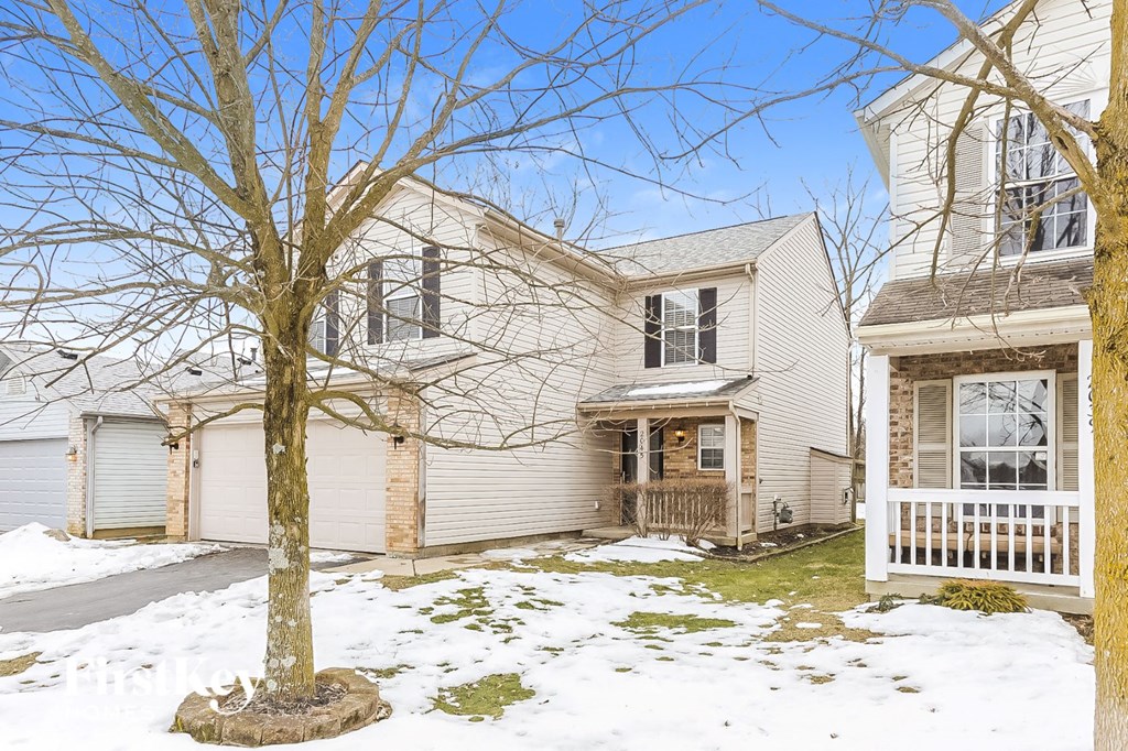 the front of a white house with snow on the ground