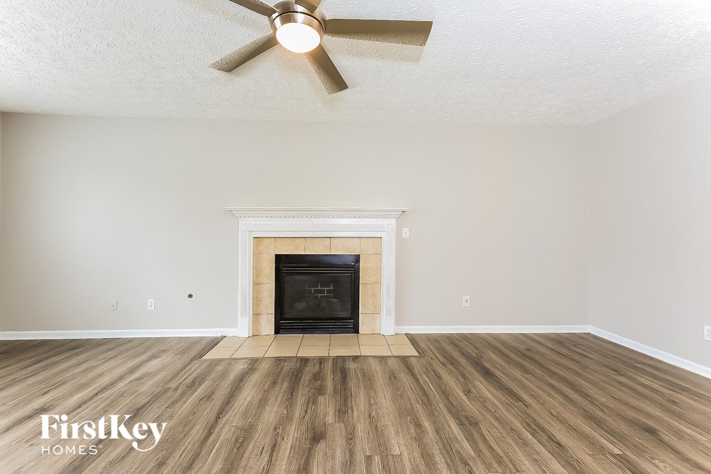 the living room of an empty house with a fireplace