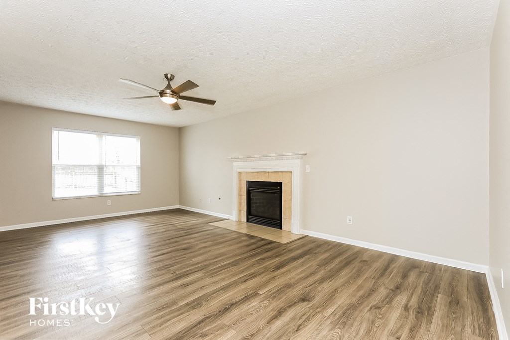 a living room with a fireplace and a ceiling fan