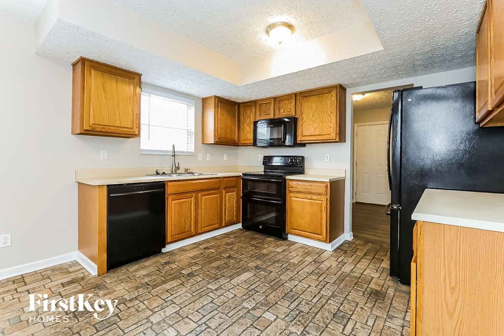 a kitchen with black appliances and wooden cabinets