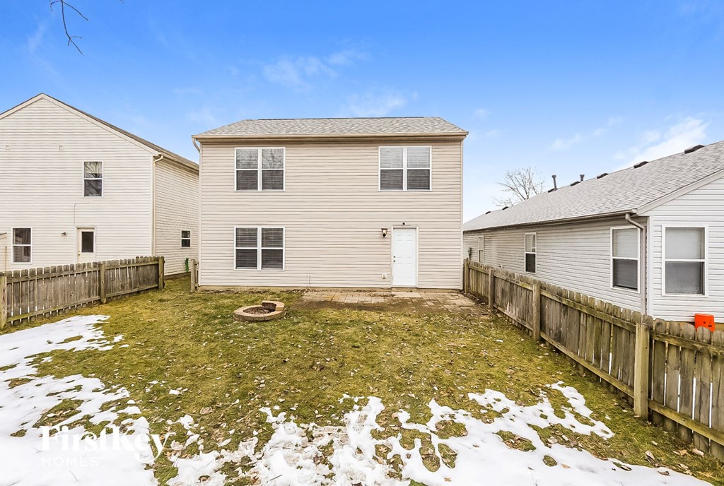 a backyard with two houses and a yard with snow