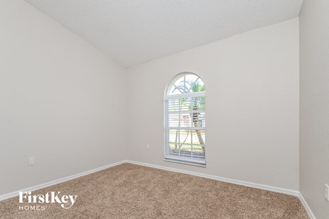 a bedroom with a large window and carpet