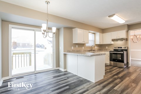 A kitchen with a stove top oven and a chandelier.