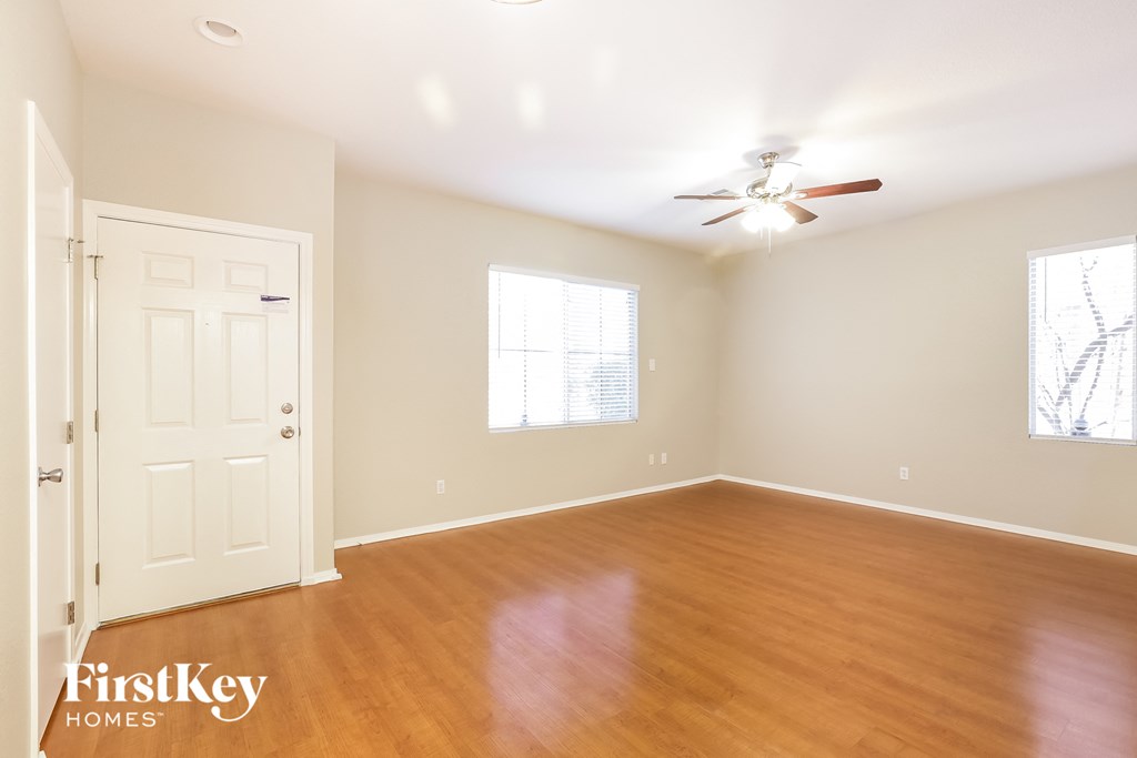 a bedroom with wood floors and a ceiling fan
