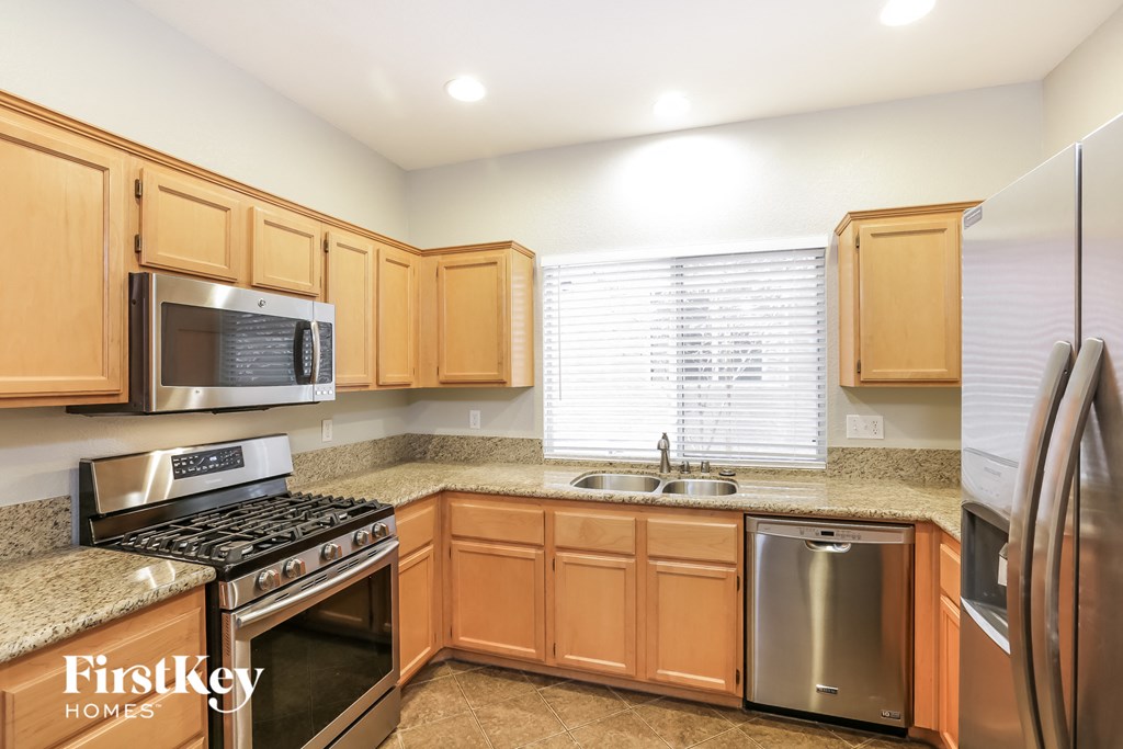 a kitchen with wooden cabinets and stainless steel appliances