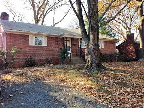a brick house with a large tree in front of it