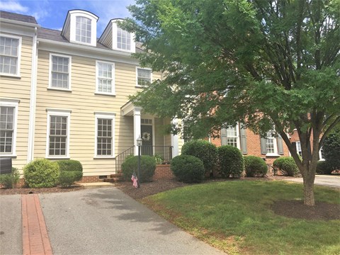 A large house with a tree in front.
