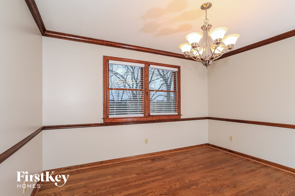 A room with wooden floors and a chandelier.