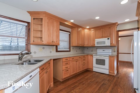 A kitchen with wooden cabinets and white appliances.