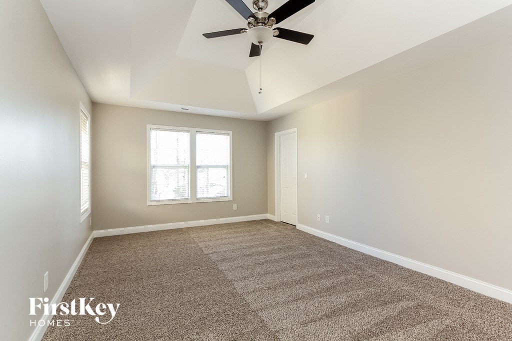 a living room with carpet and a ceiling fan