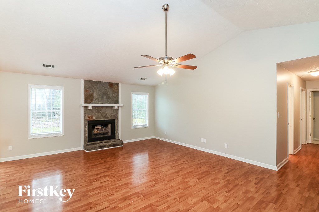 A room with a fireplace and a ceiling fan.