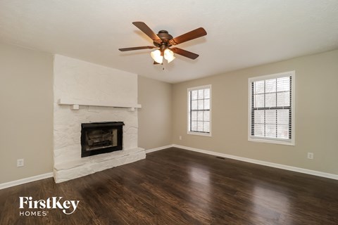 a living room with a ceiling fan and a fireplace