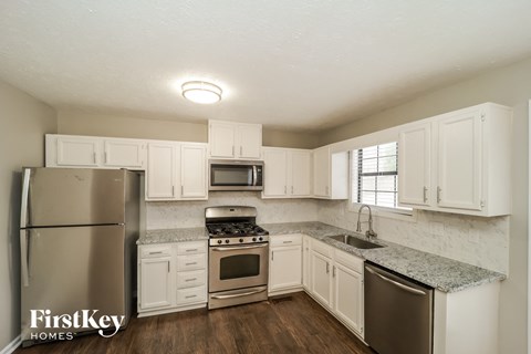 a kitchen with white cabinets and stainless steel appliances