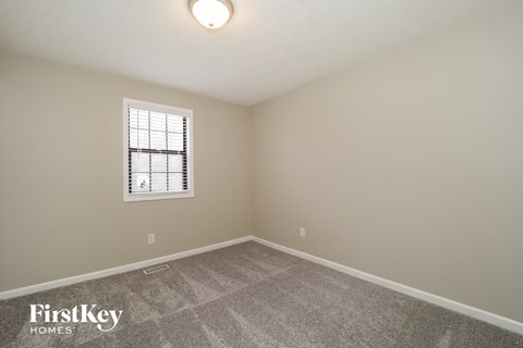 a bedroom with a carpeted floor and a window