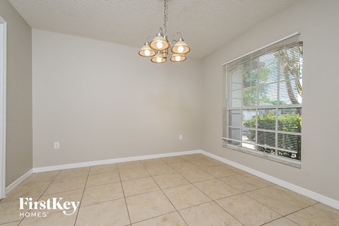 a dining room with a large window and a tiled floor